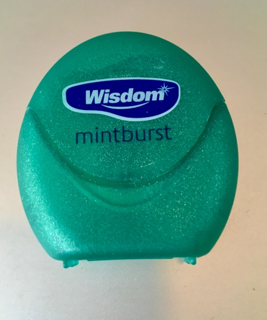 A green packet of Wisdom dental floss