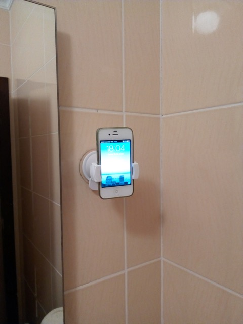 An iPhone in the Oral B Genius wall holder