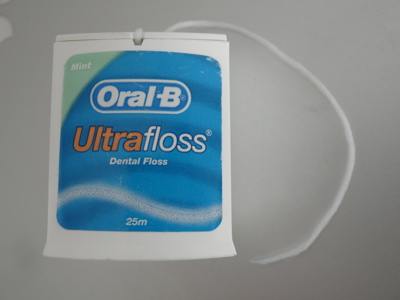 A packet of Oral B Ultra Floss against a light grey background A packet of Oral B Ultra Floss against a light grey background