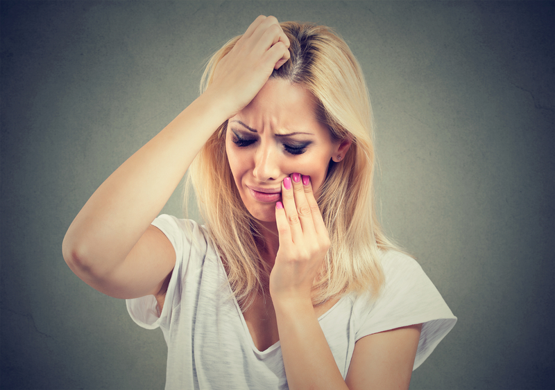 woman holding her face in pain