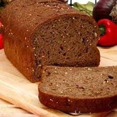 A loaf of wholemeal bread with one slice cut.