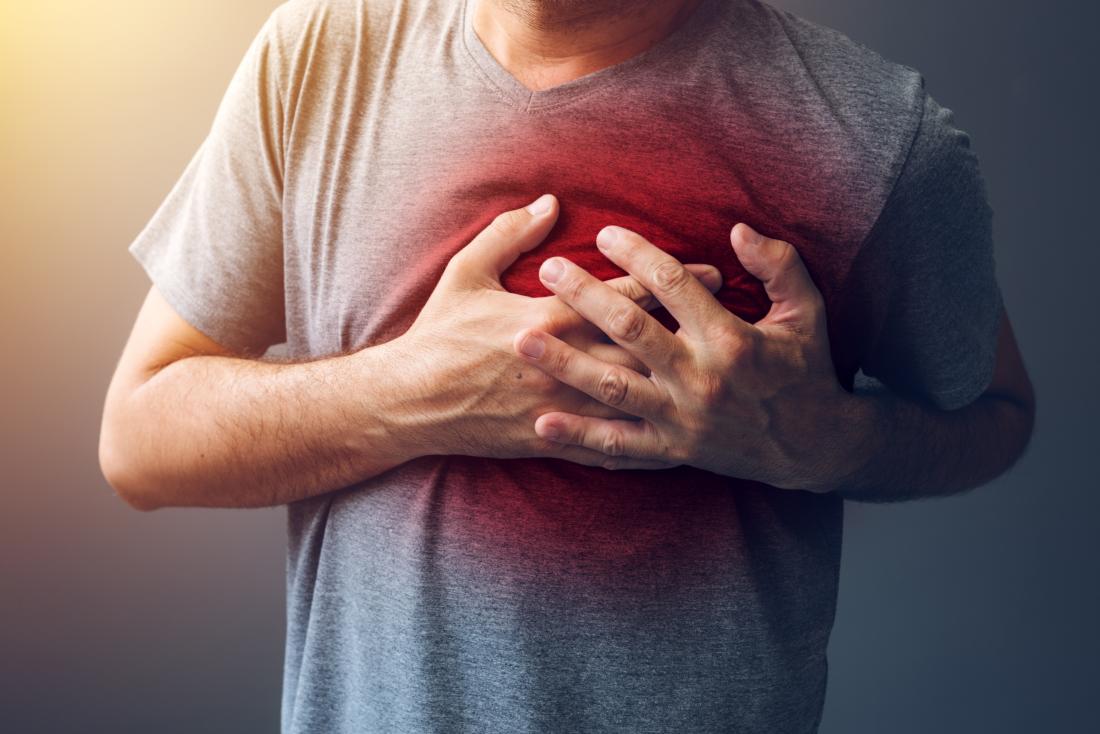 Man holding his chest with his grey shirt turning red Man holding his chest with his grey shirt turning red