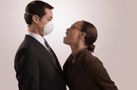 Woman breathes over a man who is wearing a face mask.